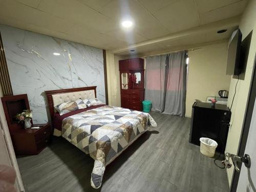 a bedroom with a bed and a tv in it at HABITACIÓN DELUXE Central in Machala