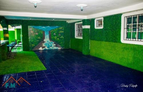 a room with a green wall with a painting of a clock at Remanso de Paz in Pedernales