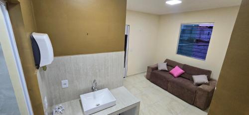 a small living room with a couch and a sink at Linda Casa 3 suítes in Belém