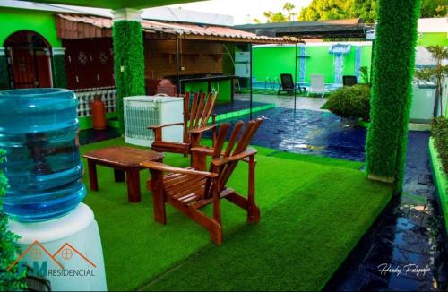 two chairs and a water cooler sitting on a lawn at Remanso de Paz in Pedernales