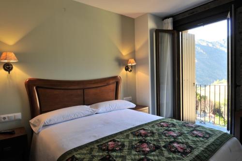 a bedroom with a bed and a window with a view at Casa Rural La Comella in Tirvia