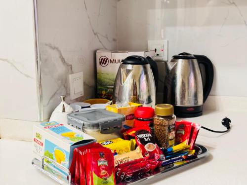 a kitchen counter with a coffee pot and food at Elysium Grand Luxury Apartments Fronting Centaurus Mall Islamabad in Islamabad