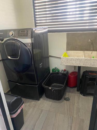 a washer and dryer in a room with a counter at La PRIMAVERA APARTMENT IN CUERNAVACA in Cuernavaca