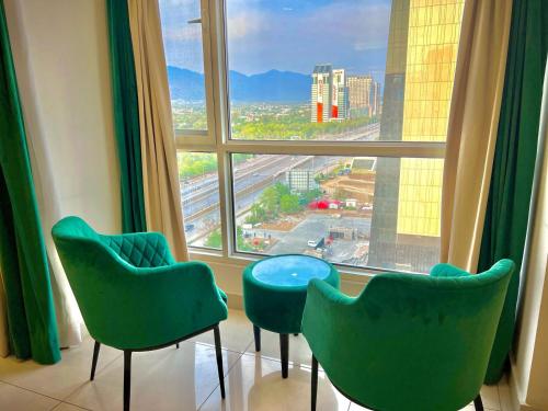 a room with three chairs and a large window at Elysium Grand Luxury Apartments Fronting Centaurus Mall Islamabad in Islamabad