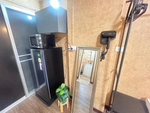 une petite pièce avec un réfrigérateur et une plante à l'intérieur dans l'établissement Secret Retro Vintage Building ห้องลับเรโทรในตึกวินเทจ, à Ban Song Hong