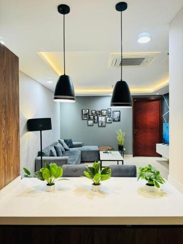 a living room with two black pendant lights at Elysium Grand Luxury Apartments Fronting Centaurus Mall Islamabad in Islamabad
