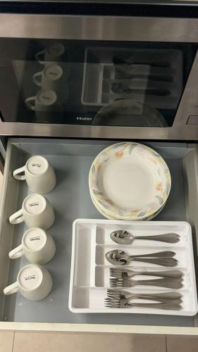a drawer of an oven with a bowl and utensils at Elysium Grand Luxury Apartments Fronting Centaurus Mall Islamabad in Islamabad