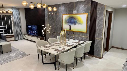 a dining room with a table and chairs at Elysium Grand Luxury Apartments Fronting Centaurus Mall Islamabad in Islamabad