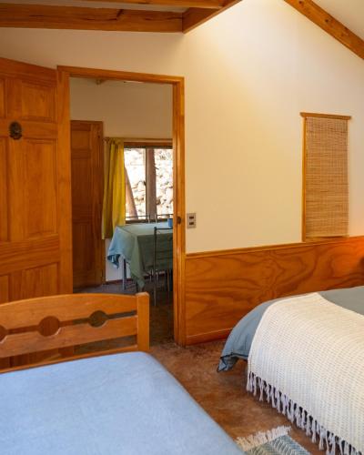 a bedroom with two beds and a mirror at El jardín secreto Pisco Elqui in Pisco Elqui