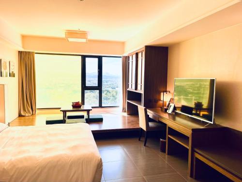 a hotel room with a bed and a desk with a computer at Fullon Hotel LihPao Resort in Houli