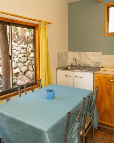 a kitchen with a table with a blue table cloth on it at El jardín secreto Pisco Elqui in Pisco Elqui