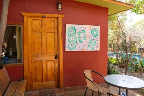 a house with a table and a painting on the wall at El jardín secreto Pisco Elqui in Pisco Elqui