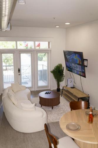 a living room with white furniture and a flat screen tv at Midtown! Close to Convention Center & Stadiums in Houston