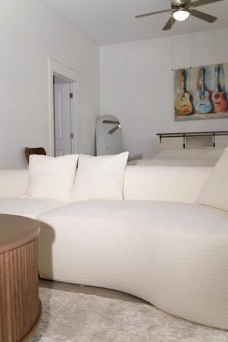 a bedroom with a large white bed with a ceiling fan at Midtown! Close to Convention Center & Stadiums in Houston