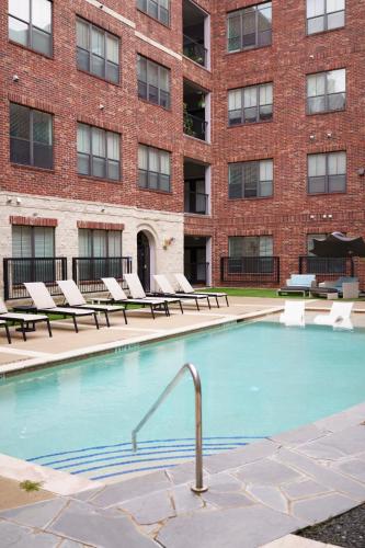a swimming pool in front of a brick building at Midtown! Close to Convention Center & Stadiums in Houston