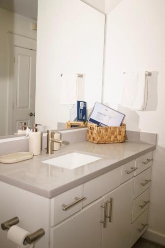 a bathroom counter with a sink and a mirror at Midtown! Close to Convention Center & Stadiums in Houston