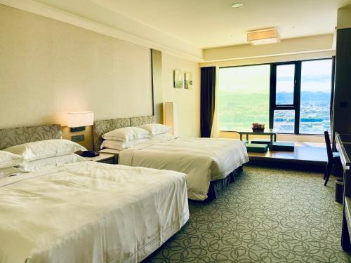 a hotel room with two beds and a large window at Fullon Hotel LihPao Resort in Houli