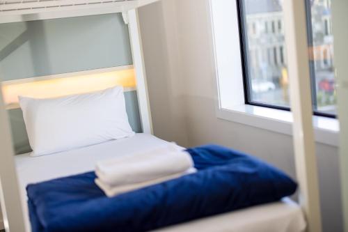 a small bed in a room with a window at Hotel Give in Christchurch
