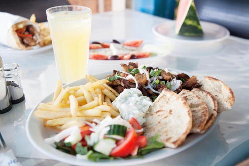 a plate of food with a sandwich and french fries at Hotel Athinoula in Kefalos