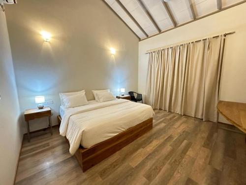 a bedroom with a bed and two tables and a window at MaVilla in Habarana