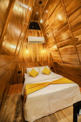 a bedroom with a bed in a wooden cabin at Sparrow's House in Weligama