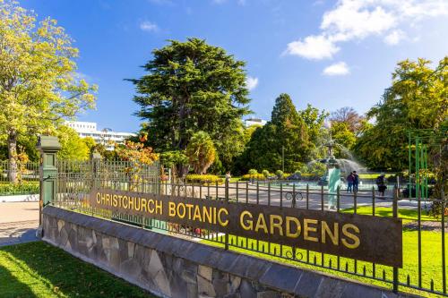 a sign for the conservatories botanic gardens on a fence at Hotel Give in Christchurch