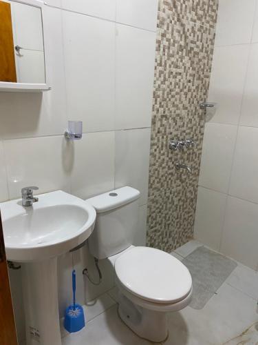 a white bathroom with a toilet and a sink at Panambí Iguazú in Puerto Iguazú