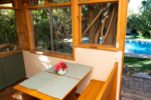 a table in a room with a vase of flowers on it at El jardín secreto Pisco Elqui in Pisco Elqui