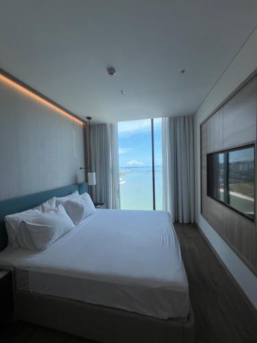 Un dormitorio con una gran cama blanca y una ventana. en Ala carte, en Ha Long