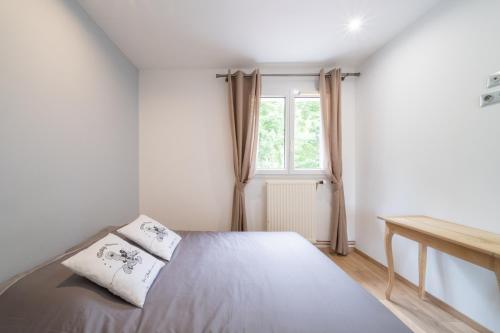 una camera da letto bianca con un letto e una finestra di Villa moderne et spacieuse Disneyland Paris a Bailly-Romainvilliers