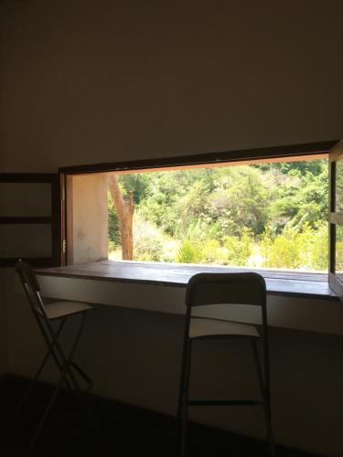a window in a room with a chair and a table at Forest Gate Sigiriya Villa in Sigiriya
