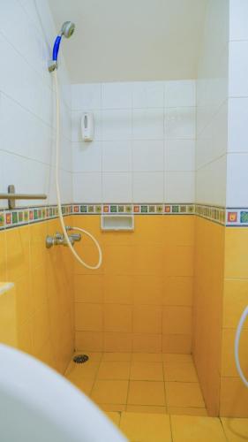 a bathroom with a shower with yellow tiles at Villa Dalia Puncak NA4-11 in Cianjur