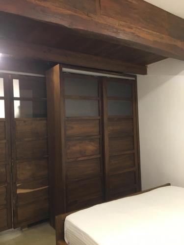 a bedroom with wooden closet doors and a bed at Forest Gate Sigiriya Villa in Sigiriya