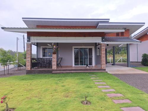 a small house with a lawn in front of it at บ้านน้ำผึ้งโฮมสเตย์ in Suan Phung