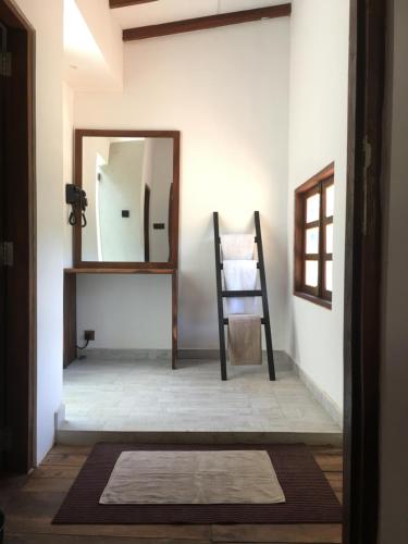 a hallway with a mirror and a wooden chair at Forest Gate Sigiriya Villa in Sigiriya