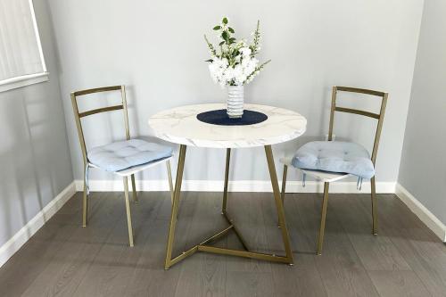 a table with two chairs and a vase with flowers on it at Cozy Contemporary one big bedroom in the Palo Alto area, close to Stanford, CA, a nice & relaxing place in Palo Alto
