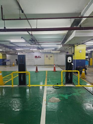 a parking garage with a green floor and yellow barriers at NEW Bangsar Trade Centre KL Mid Valley LRT Bangsar in Kuala Lumpur