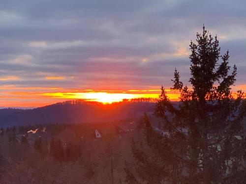 a sunset with the sun setting in the background at Einfamilienhaus in Zorge in Zorge