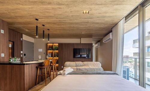 a bedroom with a large bed and a kitchen at New Time Apto 1303 in Maceió