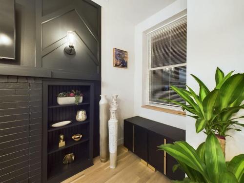 a living room with a black cabinet and a plant at The Velvet Jazz Haus in Chicago