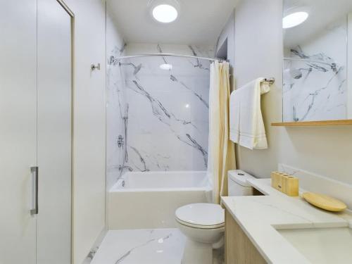 a white bathroom with a shower and a toilet at The Velvet Jazz Haus in Chicago