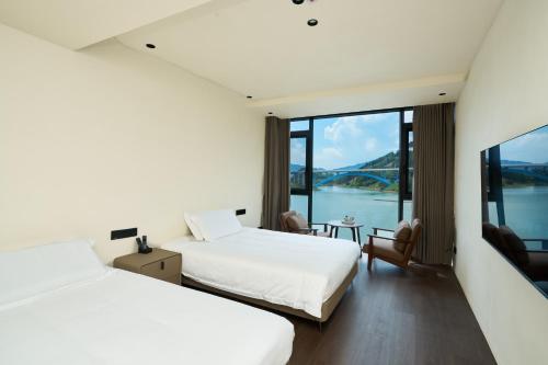 a hotel room with two beds and a view of the water at The Lake View Deyishe Resort in Thousand Island Lake in Thousand Island Lake