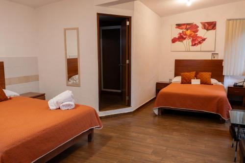 a hotel room with two beds and a mirror at Tu cabaña Cuernavaca - hospedaje by Arcadia in Cuernavaca