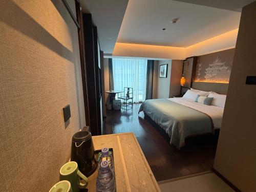 a hotel room with a bed and a table at Till Bright Hotel, Foshan Shunde Ronggui Station Branch in Shunde