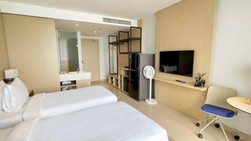 a hotel room with a bed and a desk and a tv at J Home The Arena Cam Ranh in Cam Ranh International Airport