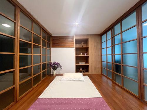 a meditation room with a purple rug and large windows at โรงแรมบลอสซั่ม เพชรบูรณ์ Blossom Hotel in Phetchabun