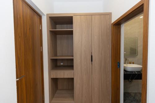 a bathroom with a wooden closet with a sink at Villa Sea in Trà Cổ