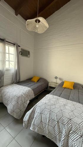 a bedroom with two beds and a ceiling at Increible Departamento en Ciudad de Mendoza, a metros de Parque Central y proximo a microcentro con cochera Pellegrini Apartments Parque Central in La Cieneguita
