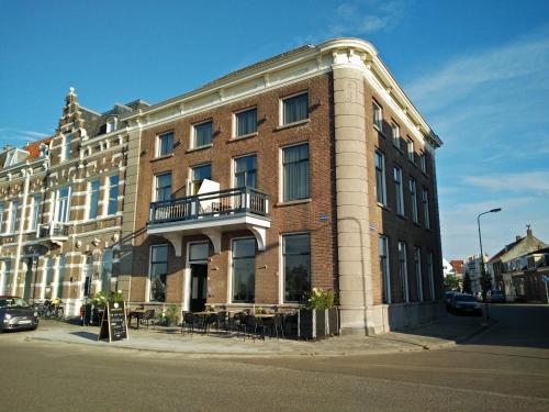 a large brick building on the corner of a street at Hotel Loskade 45 in Middelburg