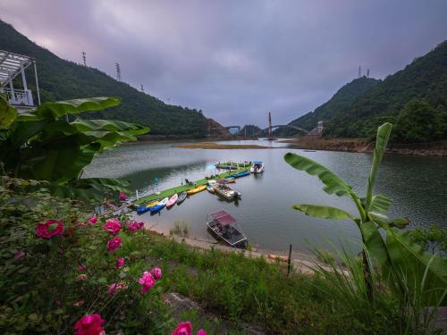 a group of boats are docked on a river at The Lake View Deyishe Resort in Thousand Island Lake in Thousand Island Lake